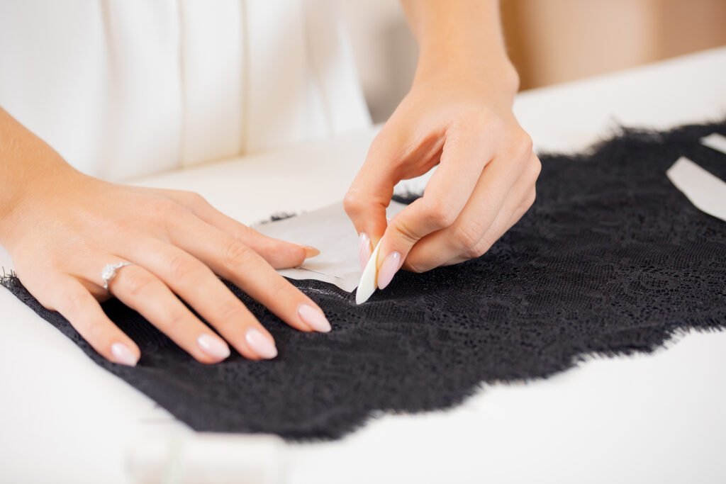 sewing workshop and tailoring. seamstress marks sketch on clothes with chalk